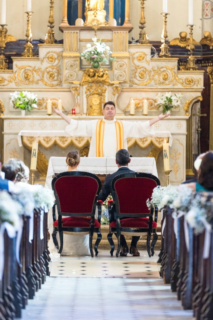 a man in a white robe standing in front of a group of people