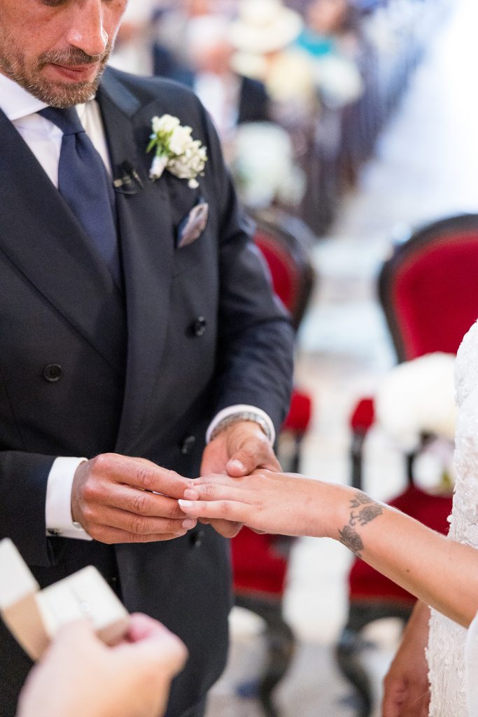 a man in a suit putting a ring on a woman's hand