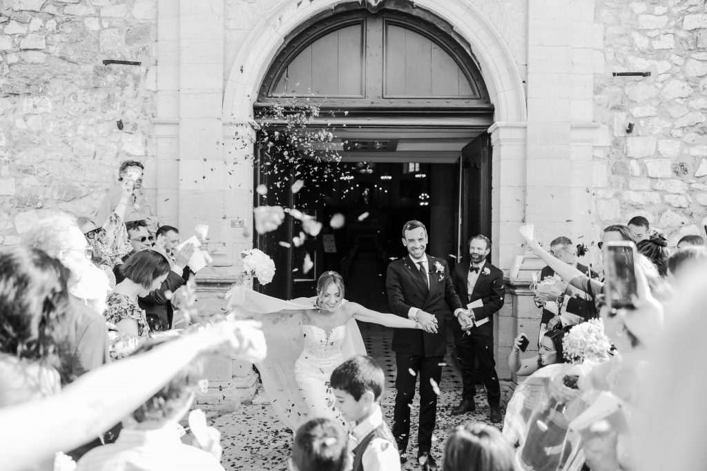 a bride and groom outside of a building with confetti