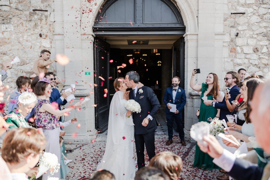 a man and woman kissing outside of a building with confetti