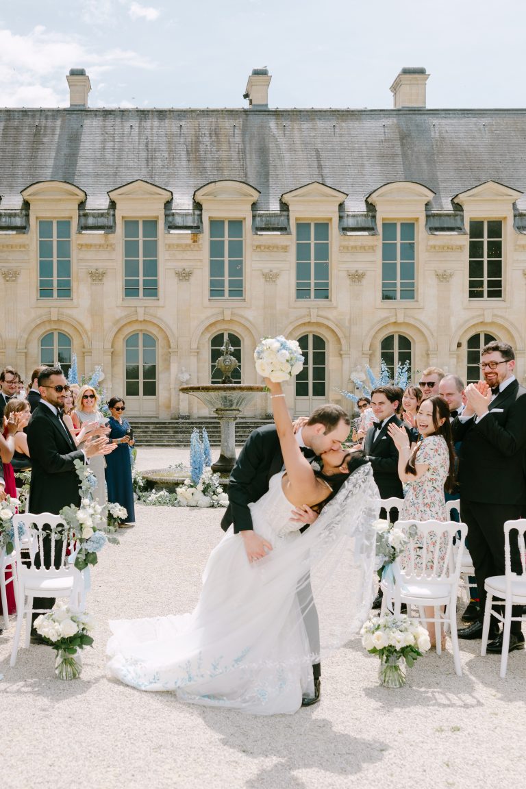 May and Thor sharing a romantic kiss at sunset during their wedding at Château de Chantilly, France.
