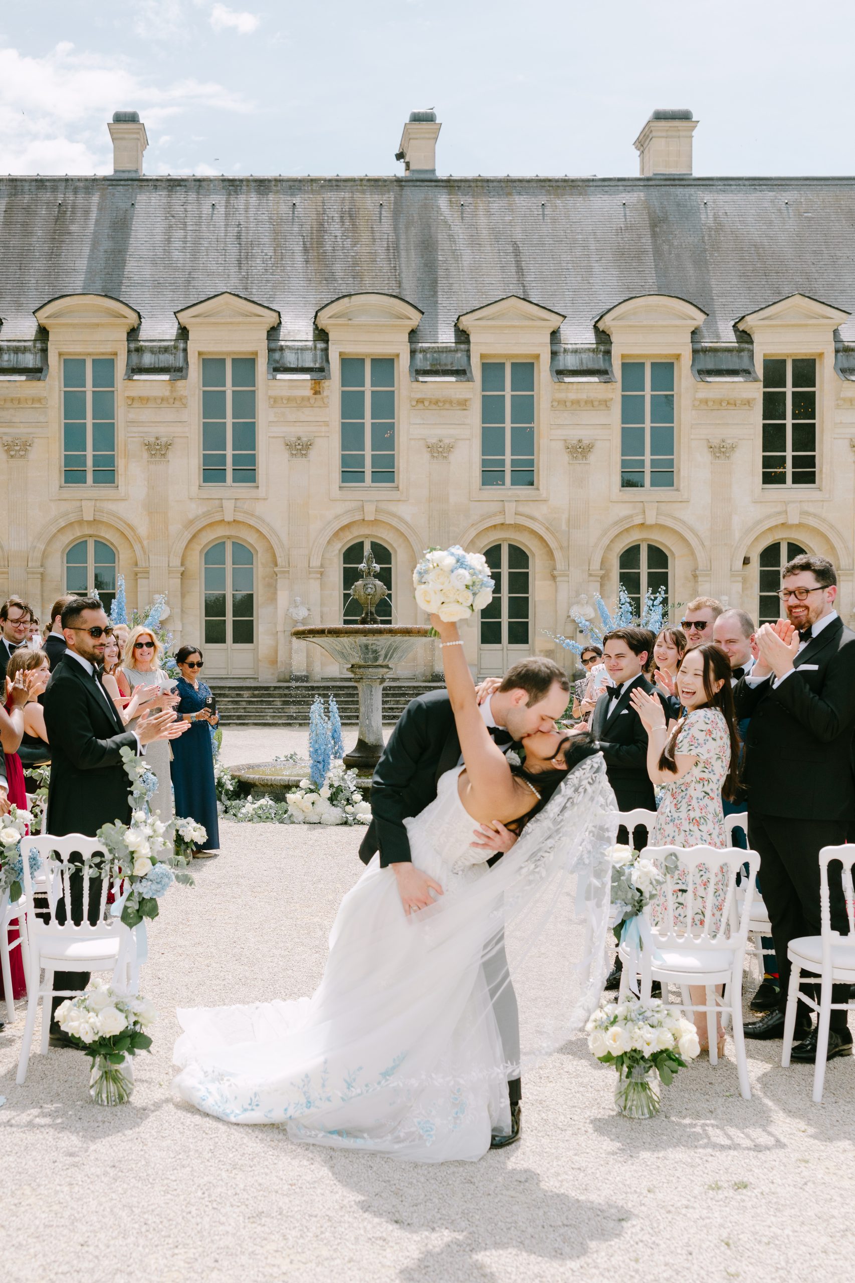 May and Thor sharing a romantic kiss at sunset during their wedding at Château de Chantilly, France.