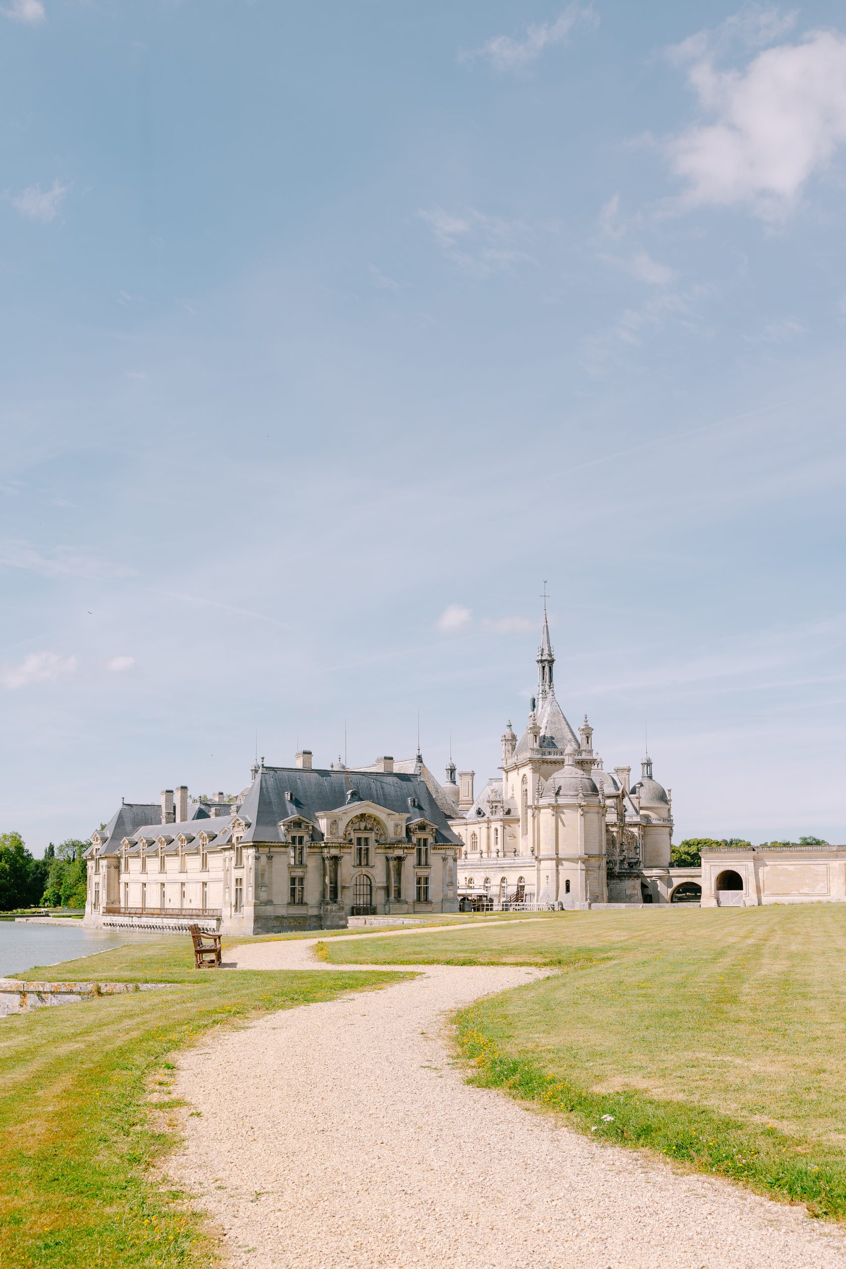 May and Thor sharing a romantic kiss at sunset during their wedding at Château de Chantilly, France.
